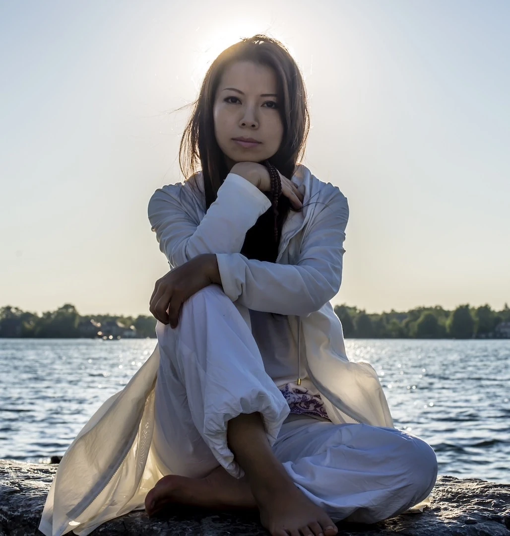 XinYi seated by the water